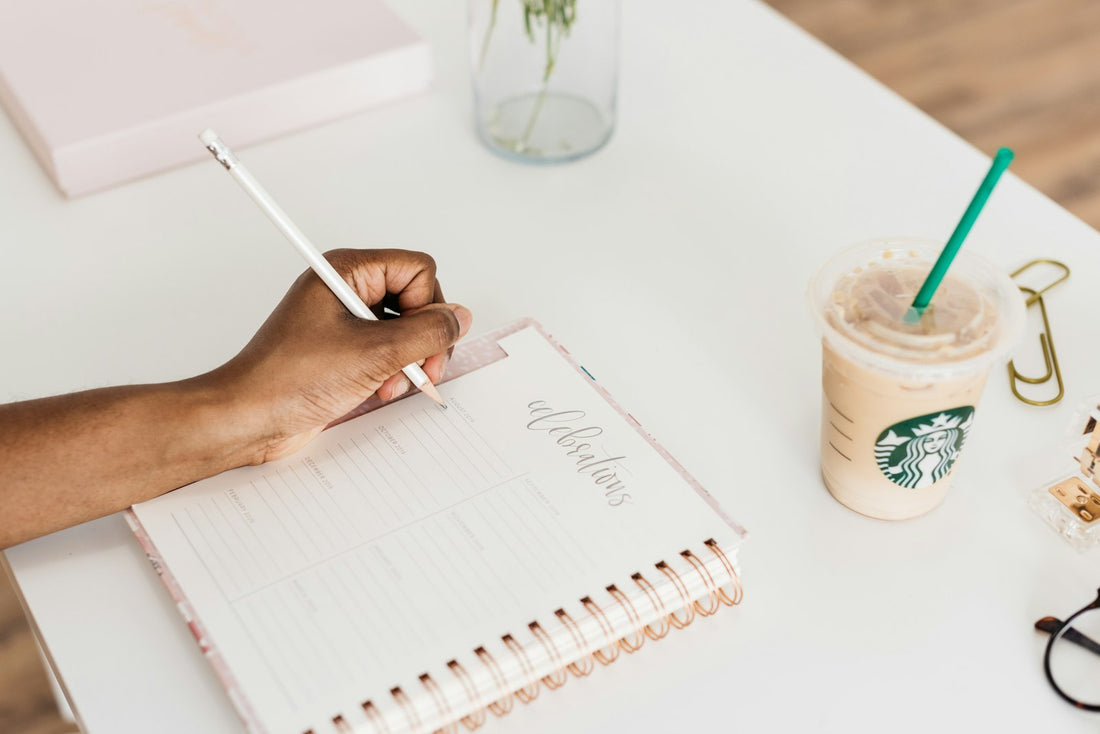 Person schreibt Ziele in einen Planer – Objectives und Key Results formulieren