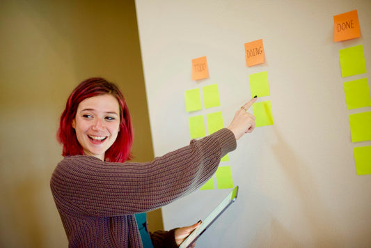 Scrum Master am Kanban-Board mit Haftnotizen – die drei Scrum Rollen in der Praxis