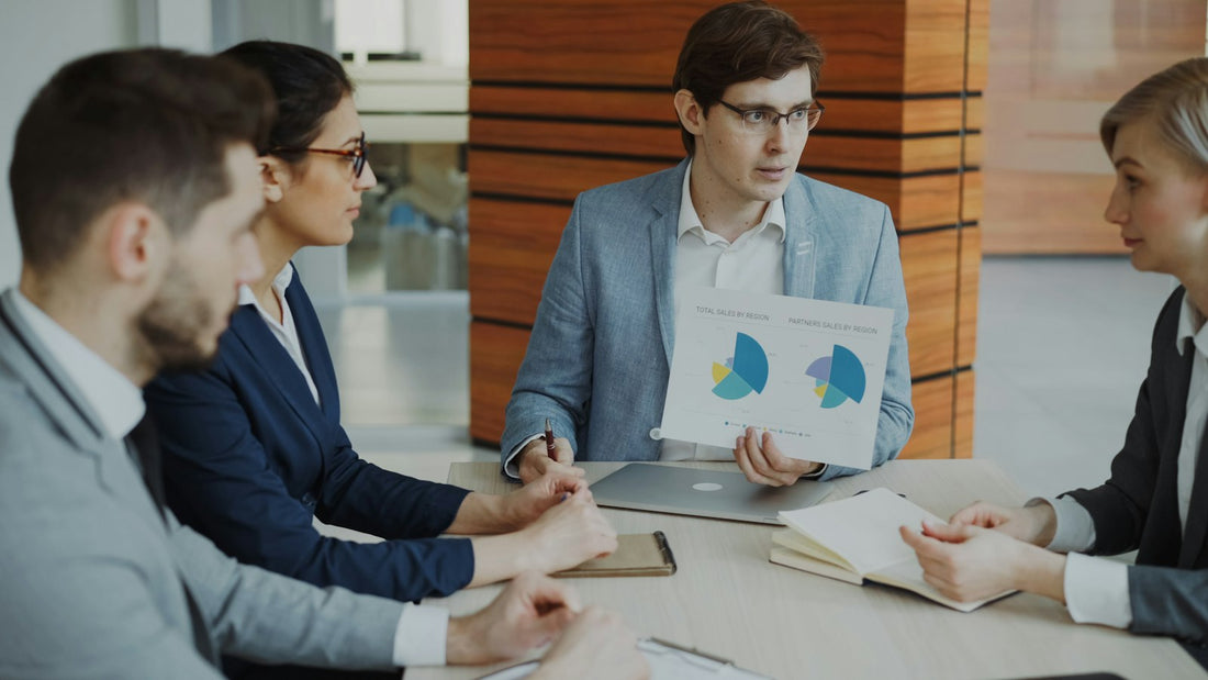 Team bespricht gemeinsam Optionen während eines Meetings, im Hintergrund sind Charts zu sehen.